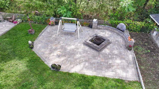 a view of a house with a big yard potted plants and large tree