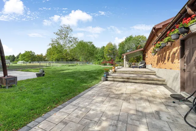 a view of a patio with a table and chairs and potted plants