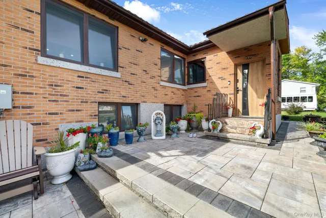 a view of a house with a yard and potted plants