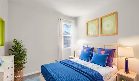 a bedroom with a bed and a painting on the wall