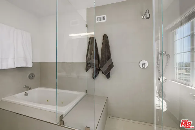 a bathroom with a tub a sink and a shower