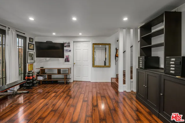 a living room with stainless steel appliances furniture and a flat screen tv