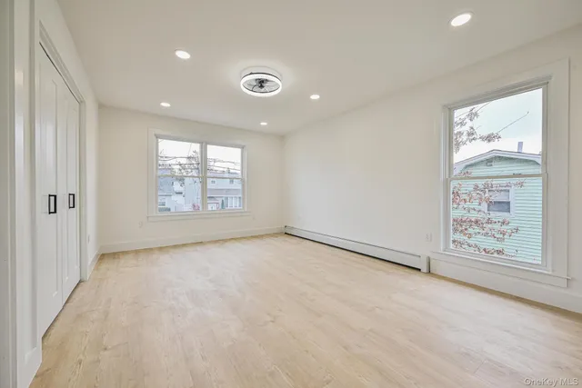 an empty room with windows and closet