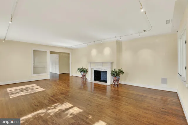 a view of a livingroom with wooden floor and a fireplace