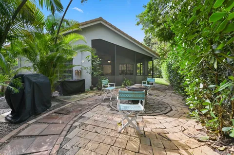 a patio with table and chairs and potted plants