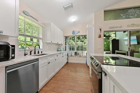 a large kitchen with a large window and stainless steel appliances
