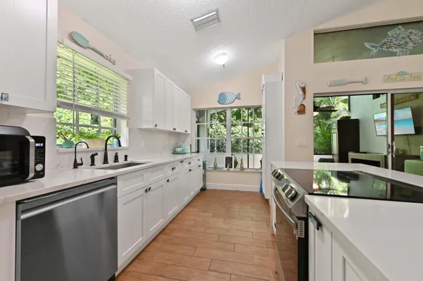a large kitchen with a large window and stainless steel appliances