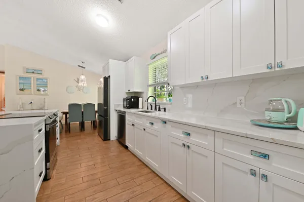a kitchen with white cabinets and sink