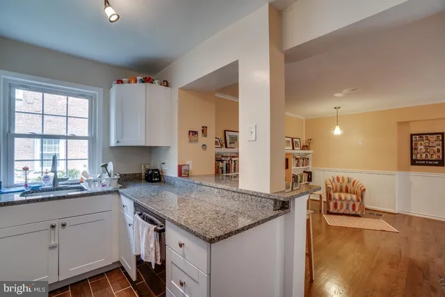 a kitchen with granite countertop a sink a stove and cabinets