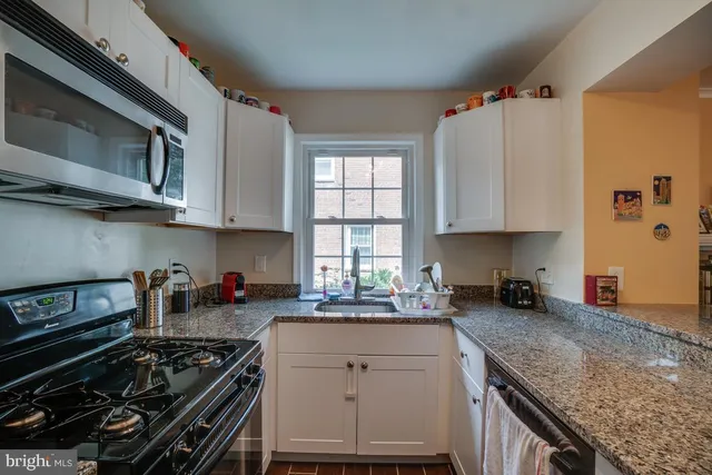 a kitchen with stainless steel appliances granite countertop a stove and a microwave