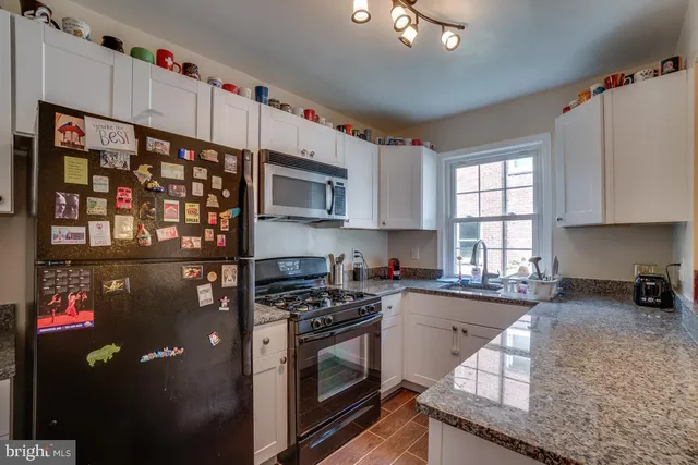 a kitchen with stainless steel appliances granite countertop a refrigerator sink and stove