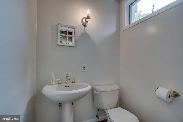 a bathroom with a sink a toilet and mirror