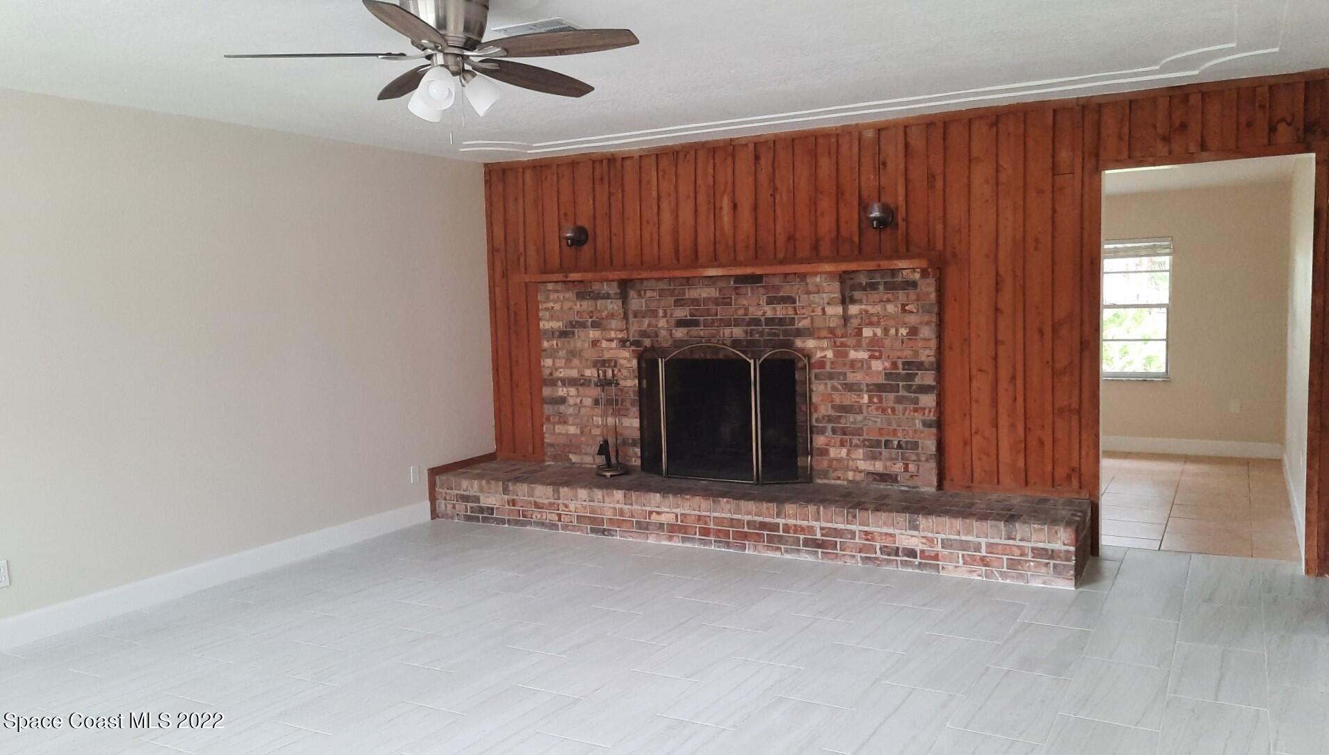 2300 Valkaria Road Malabar, FL 32950 - Photo 2 of 15 an empty room with fireplace and fan