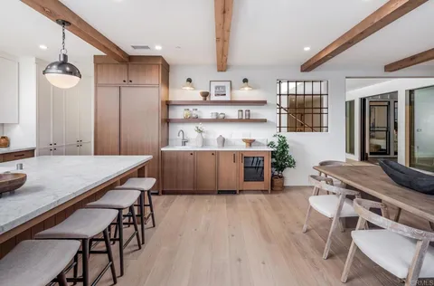 a room with stainless steel appliances kitchen island granite countertop furniture and a view of kitchen