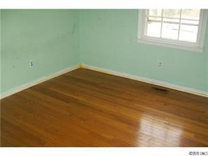 6015 Pepperhill Road Charlotte, NC 28212 - Photo 11 of 12 an empty room with wooden floor and windows