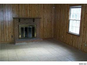 6015 Pepperhill Road Charlotte, NC 28212 - Photo 6 of 12 a view of an empty room with wooden floor and a fireplace