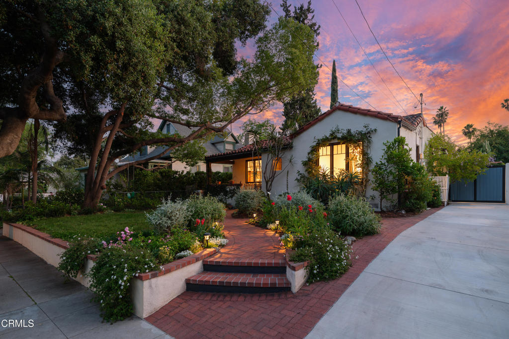 a front view of a house with a yard and potted plants