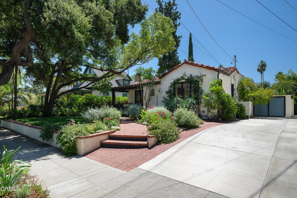 859 Sunset Avenue Pasadena, CA 91103 - Photo 2 of 76 a front view of a house with lots of green space and a bench