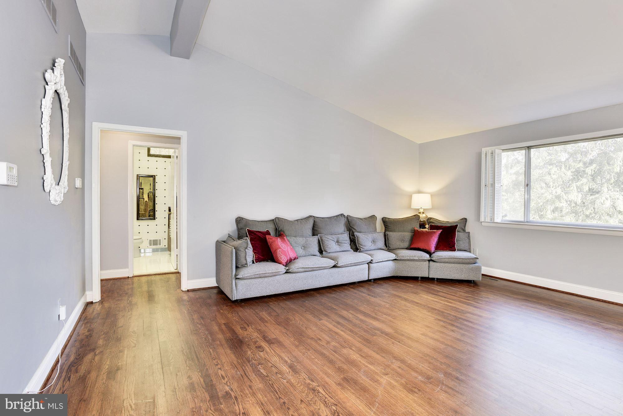 4614 Hawksbury Road Baltimore, MD 21208 - Photo 2 of 33 a living room with couches and a potted plant next to a window