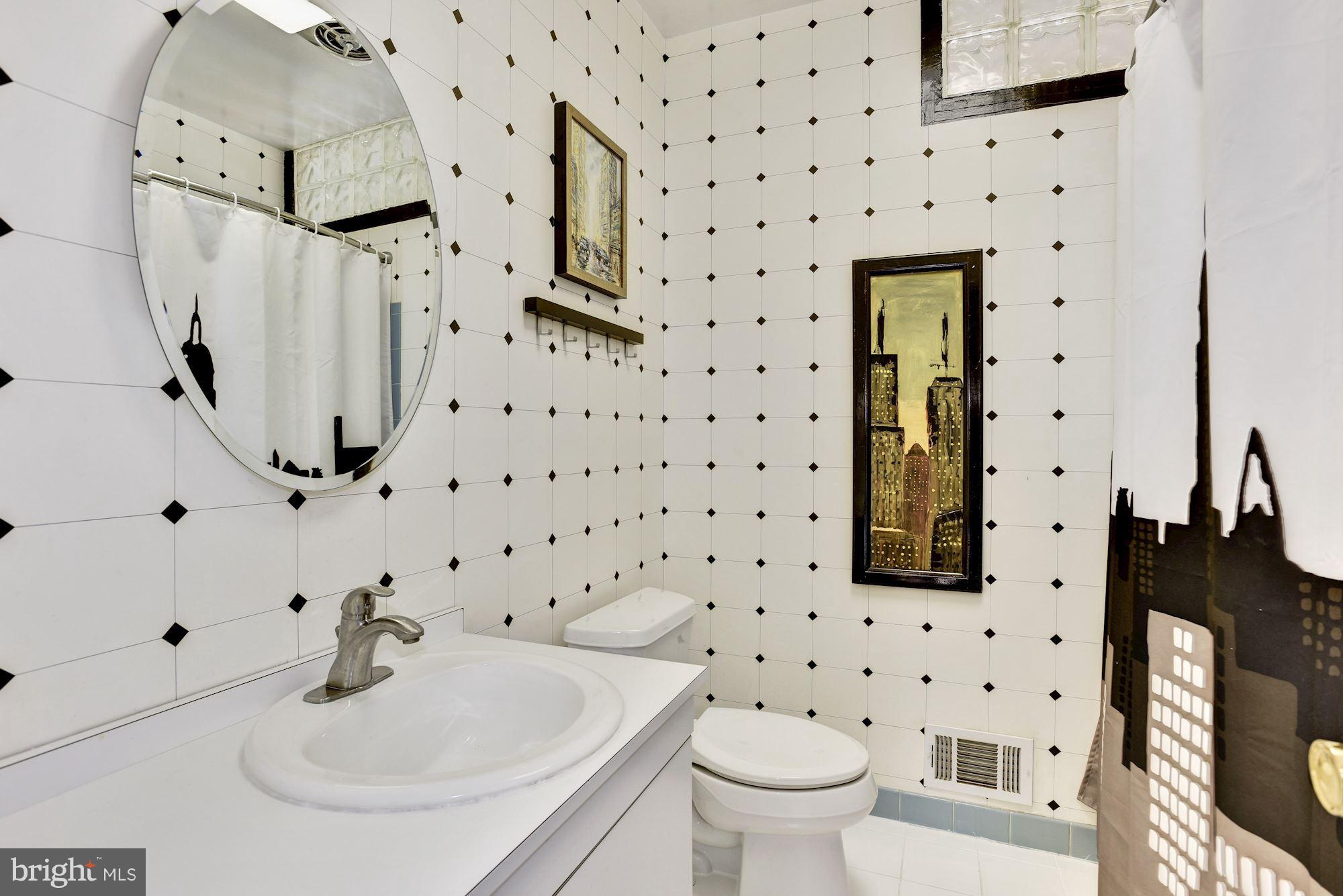 4614 Hawksbury Road Baltimore, MD 21208 - Photo 18 of 33 a bathroom with a sink toilet and shower