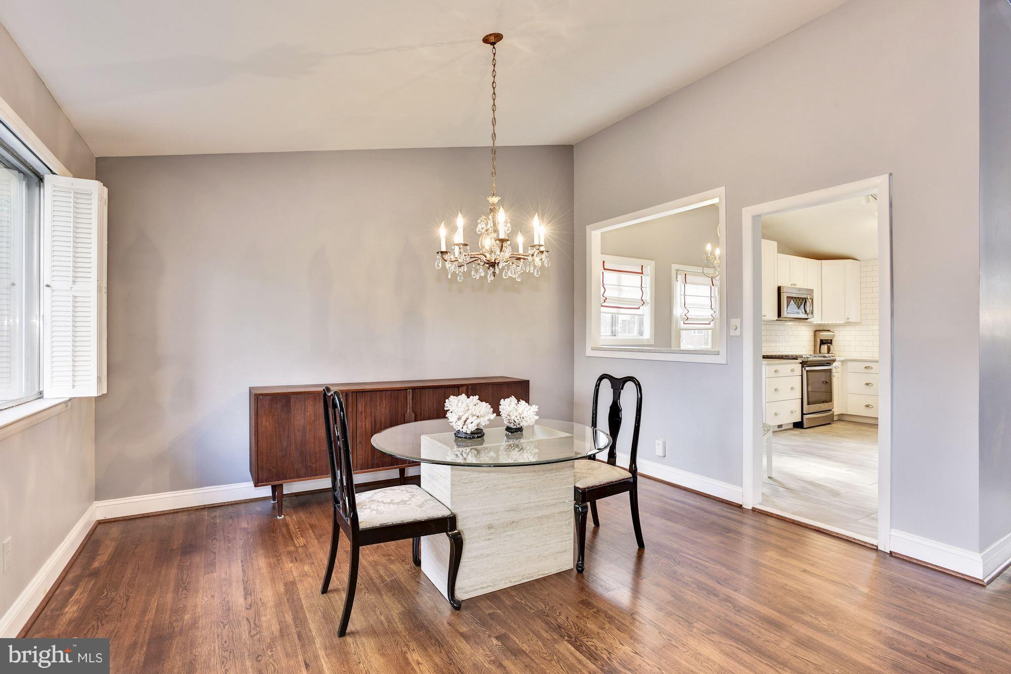 4614 Hawksbury Road Baltimore, MD 21208 - Photo 6 of 33 a dining room with furniture wooden floor a rug and a chandelier