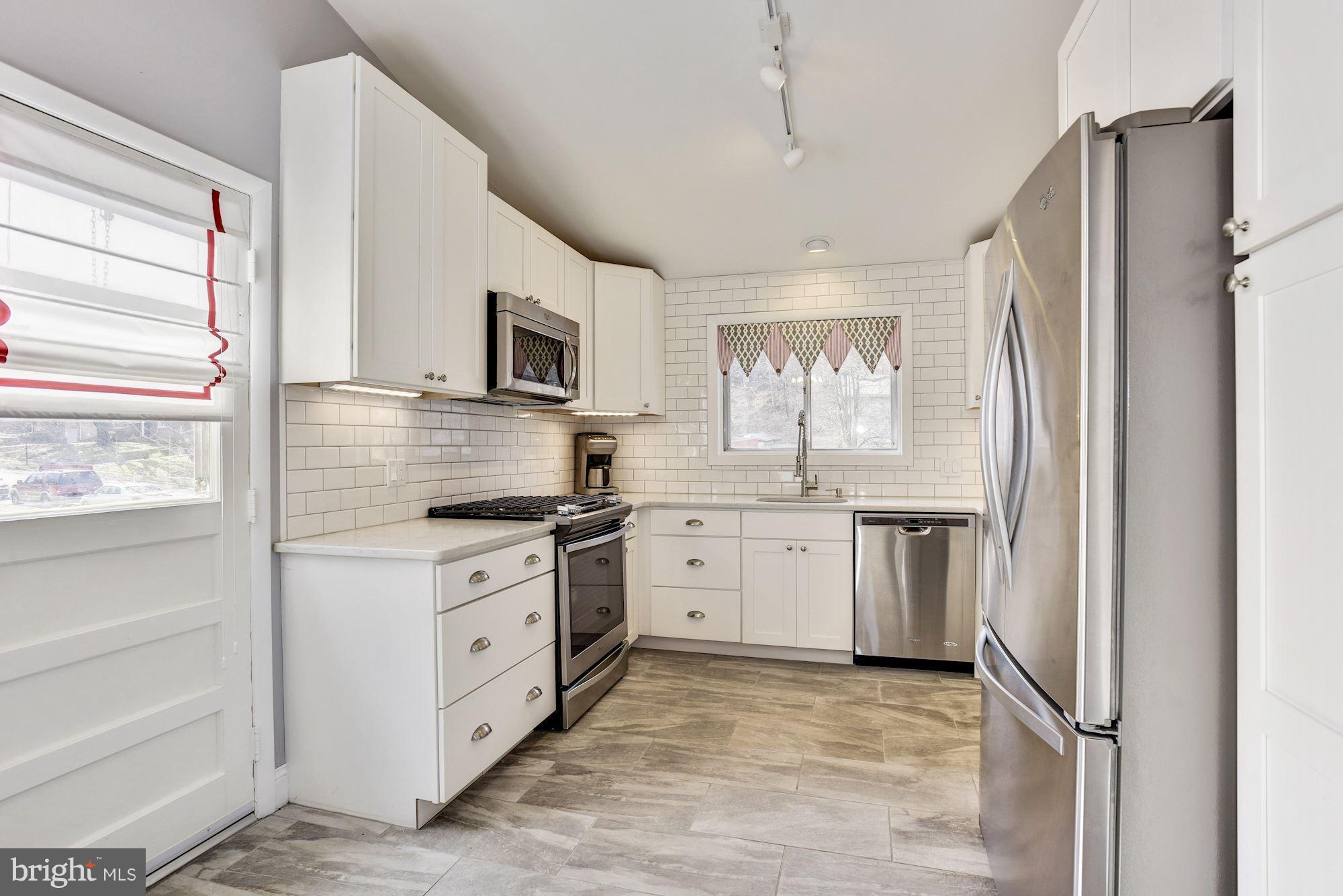 4614 Hawksbury Road Baltimore, MD 21208 - Photo 8 of 33 a kitchen with white cabinets and a refrigerator