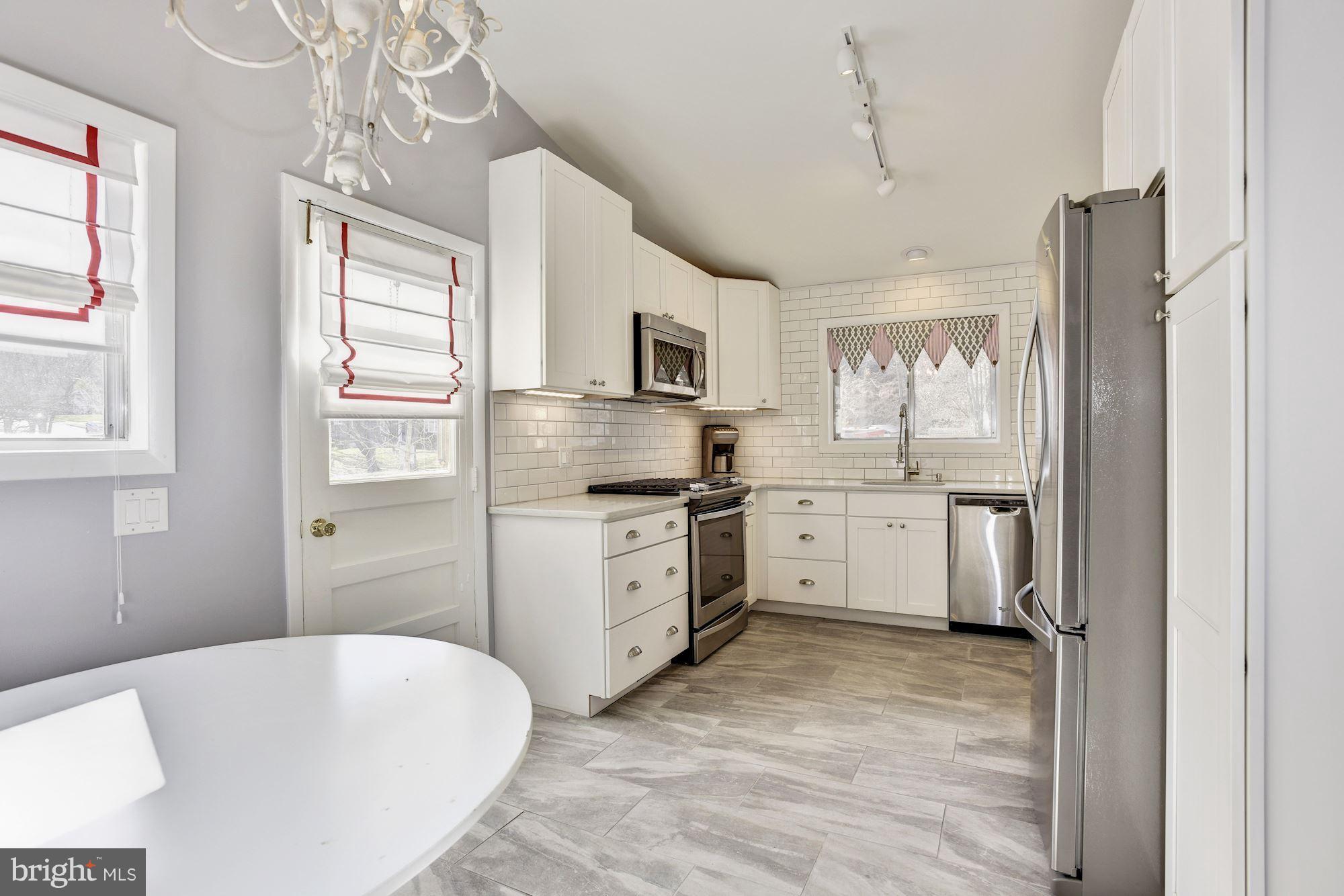 4614 Hawksbury Road Baltimore, MD 21208 - Photo 10 of 33 a kitchen with white cabinets and stainless steel appliances