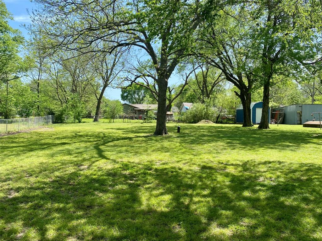 1115 South 6th Street Bonham, TX 75418 - Photo 18 of 23 a view of a grassy field with trees