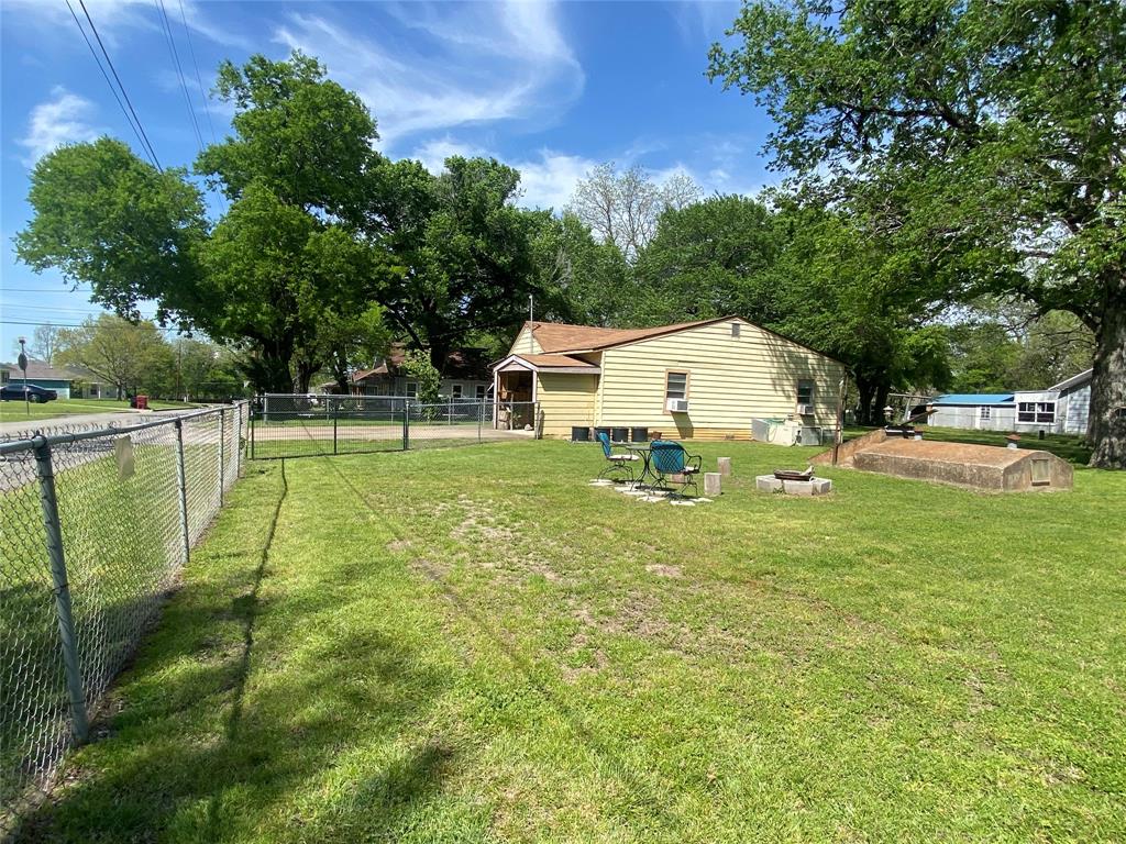 1115 South 6th Street Bonham, TX 75418 - Photo 19 of 23 a white house with a big yard and large trees