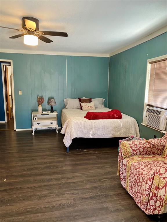 1115 South 6th Street Bonham, TX 75418 - Photo 10 of 23 a bedroom with a bed and a chandelier