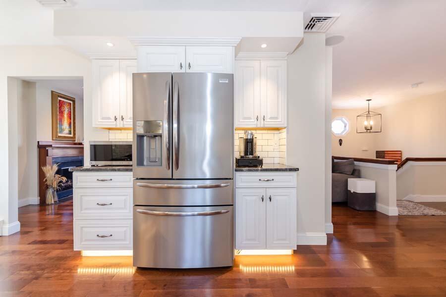 31 Captain Carleton's Road Cotuit, MA 02635 - Photo 7 of 32 a kitchen with a refrigerator and white cabinets