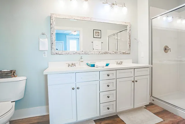 a bathroom with a double vanity sink mirror and toilet