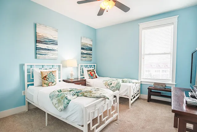 a bedroom with two beds and window