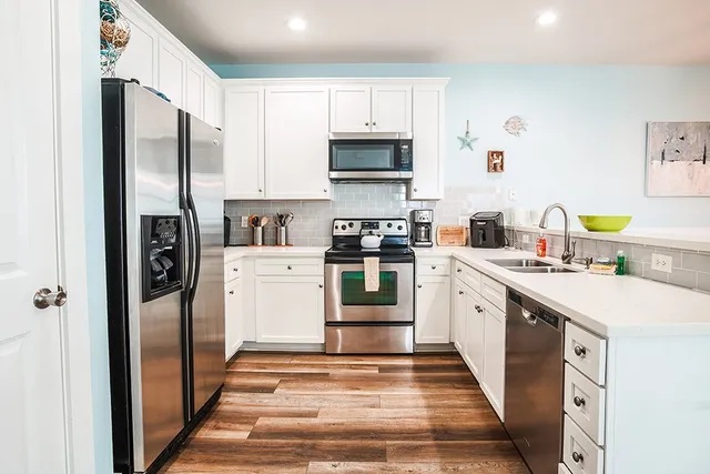 a kitchen with stainless steel appliances a refrigerator sink and microwave