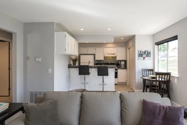 a living room with furniture and kitchen view