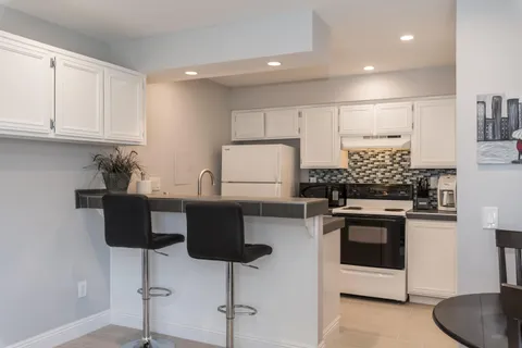 a kitchen with stainless steel appliances granite countertop a stove a sink and a refrigerator