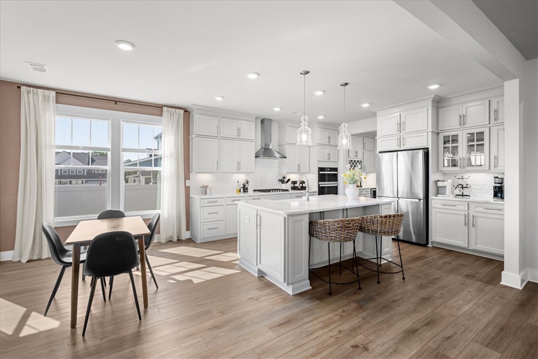 621 Wh Kay Lane Anderson, SC 29621 - Photo 9 of 50 A contemporary kitchen features a neutral pallet color cabinetry and stainless steel appliances, complemented by rich luxury vinyl plank flooring.
