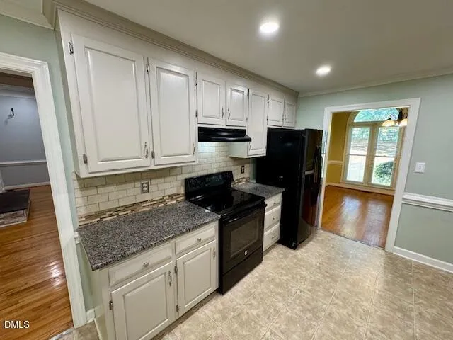 a kitchen with granite countertop a refrigerator stove and sink