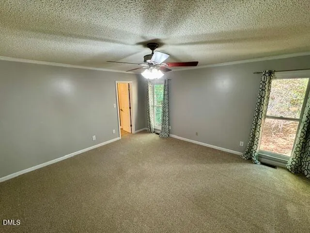 en empty room with windows and fan