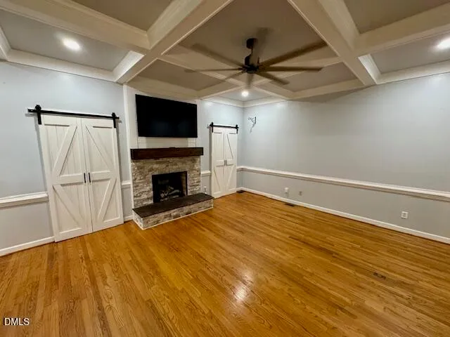 an empty room with windows a fireplace and a chandelier fan