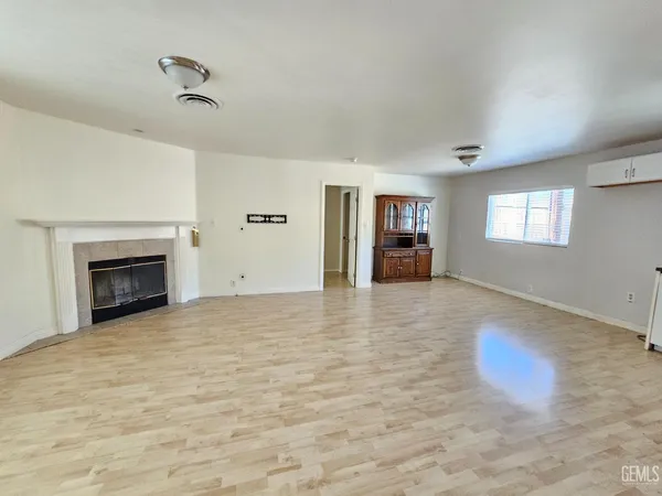 a view of an empty room with a fireplace and a window