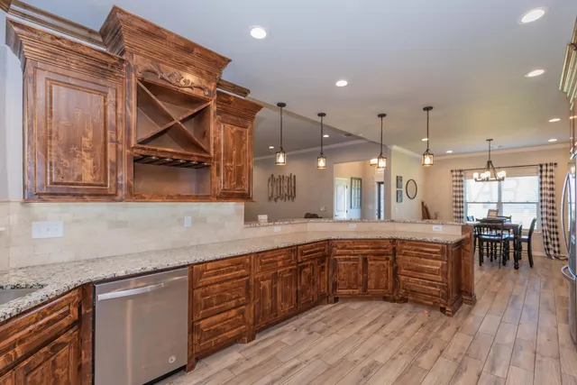 a kitchen with wooden floors and wooden cabinets