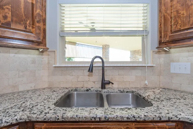 a kitchen with granite countertop a sink and a window