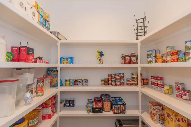 a utility room with lots of clutter and cabinets