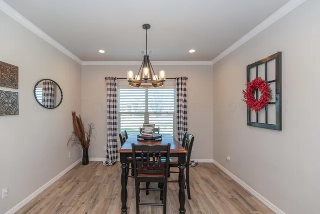 a view of a dining room with furniture a chandelier and wooden floor