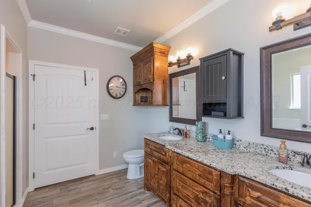 a bathroom with a granite countertop sink toilet a mirror and vanity