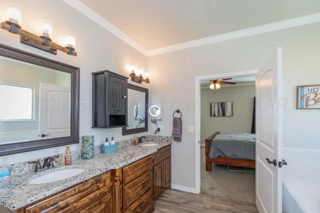 a en suite bathroom with a granite countertop sink and a mirror