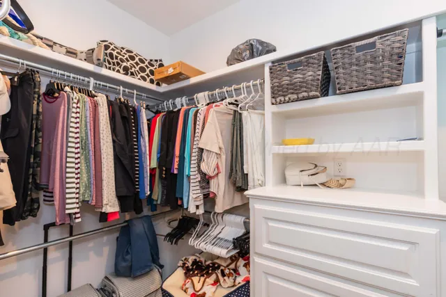 a view of walk in closet with clothes and shoes