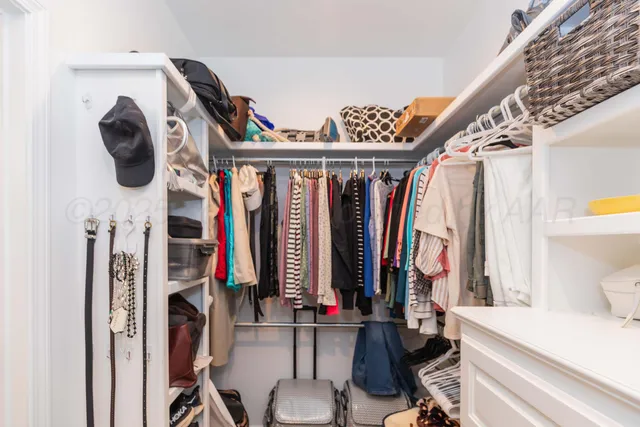 a view of walk in closet with clothes and shoes