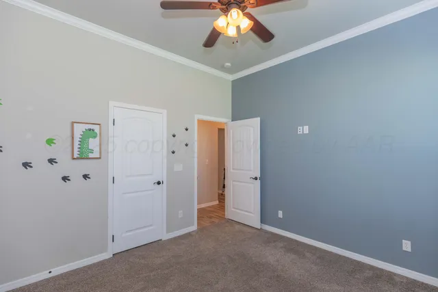 a view of an empty room with window and a kitchen space